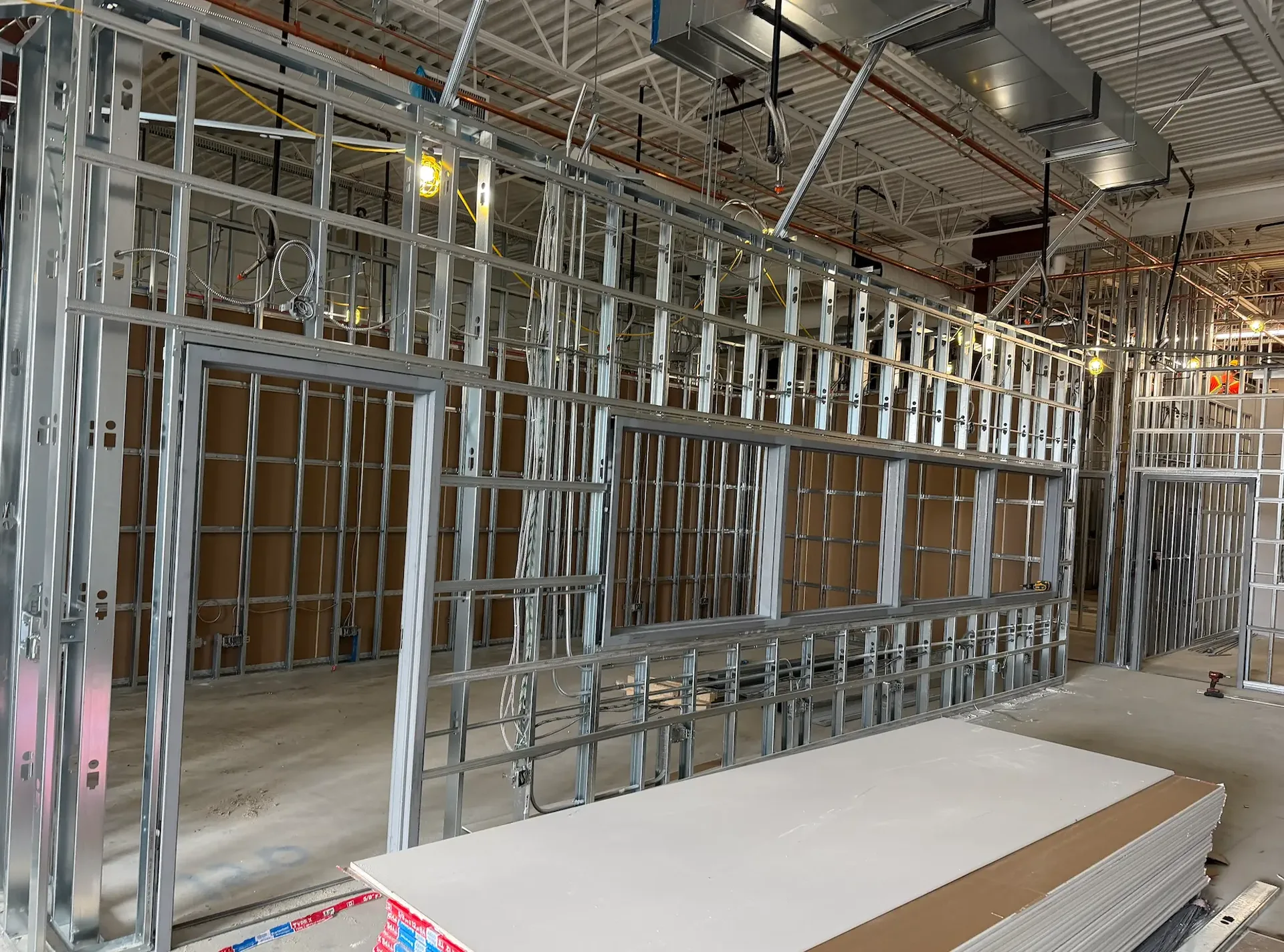 Light-gauge steel stud framing with window and door openings on a Toronto commercial fit-out